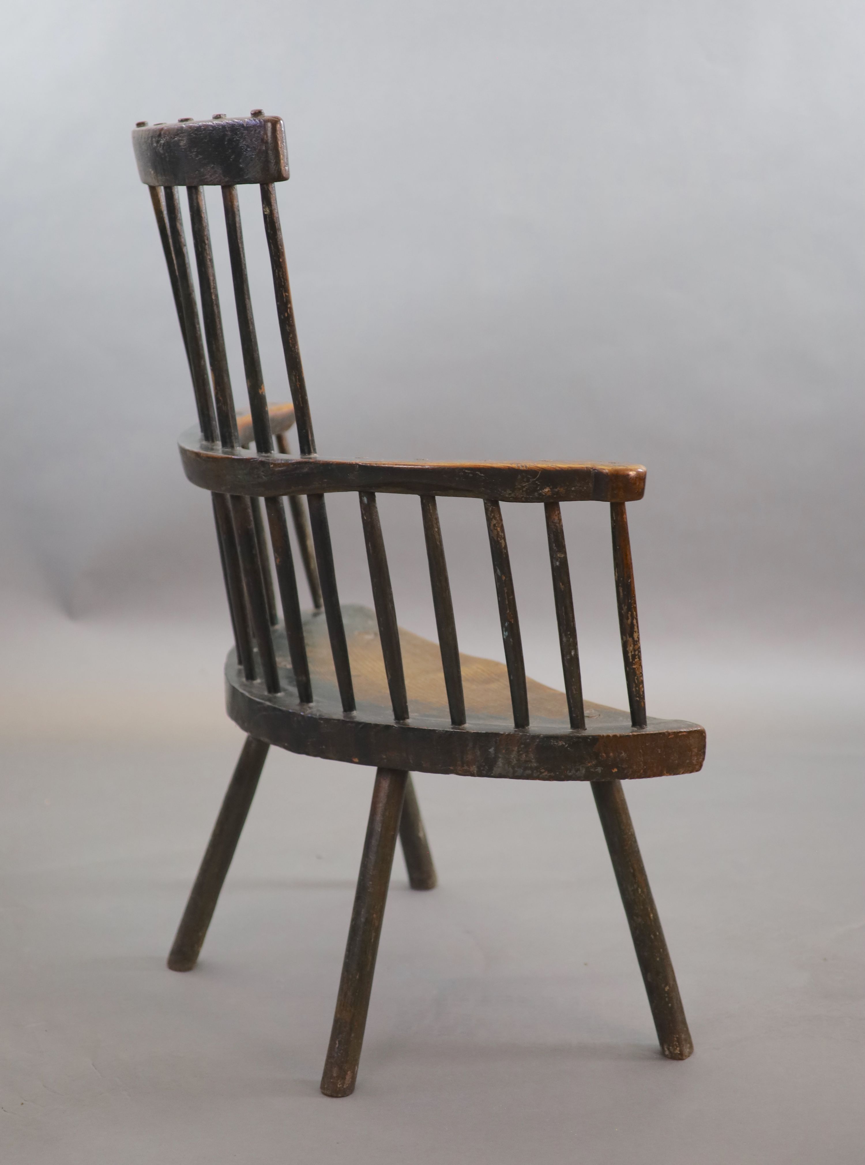 An 18th century primitive vernacular comb-back elbow chair, possibly Welsh, 70cm wide, 34cm deep, 99cm high.